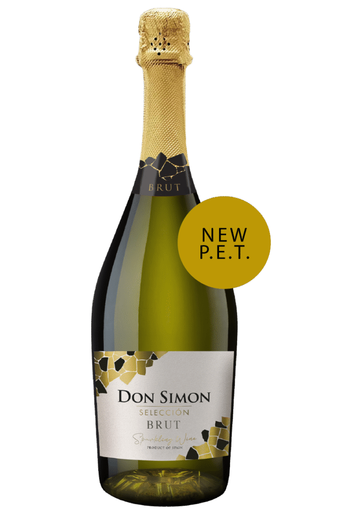 A bottle of Don Simon Selección Brut sparkling wine with gold foil on the neck and a round yellow label that reads NEW P.E.T. attached near the top.