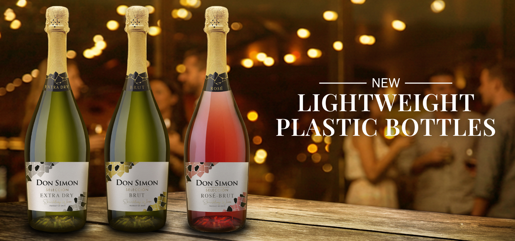 Three Don Simon sparkling wine bottles (Extra Dry, Brut, Rosé Brut) on display with a blurred background of people socializing and string lights, alongside the text: “New Lightweight Plastic Bottles.”.